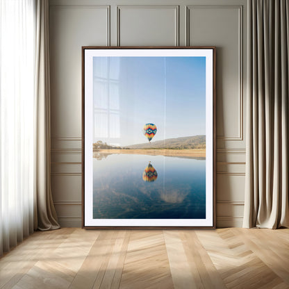 Canvas of a hot air balloon floating above a calm lake with soft reflections and vibrant sky, ideal for modern minimalist or adventure-themed home decor.