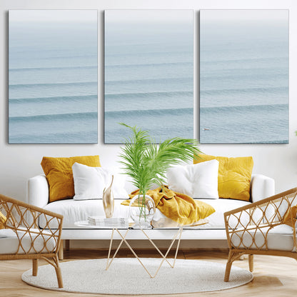 Framed canvas of repeating ocean waves with a distant solo surfer, ideal for minimalist ocean or calm coastal wall decor.
