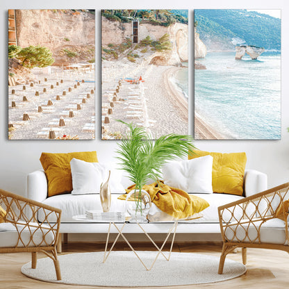 Wall art of a calm Mediterranean beach with rows of sun loungers and umbrellas in soft pastel tones, perfect for light coastal or vacation-themed decor.