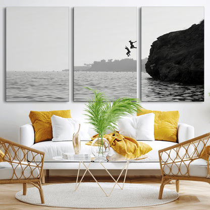 Black and white canvas of two figures cliff jumping into the sea, captured with moody tones, ideal for modern coastal or adventure-themed home decor.   2/2