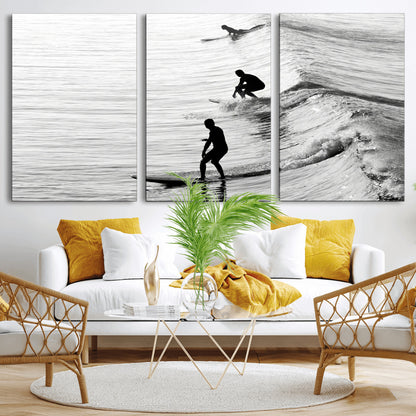 Black and white photo of surfers riding waves in a moody, high-contrast scene, ideal for modern coastal or surf-inspired home decor.
