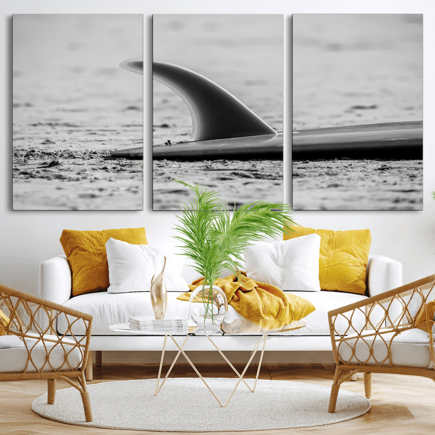 A black and white close-up of a surfboard fin resting on the sandy shore, highlighting minimalist beach aesthetics and classic surf culture.