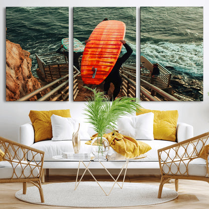 A surfer carrying a bold orange surfboard down a rugged staircase toward the ocean, bathed in golden hour light, capturing the energy of coastal adventure.