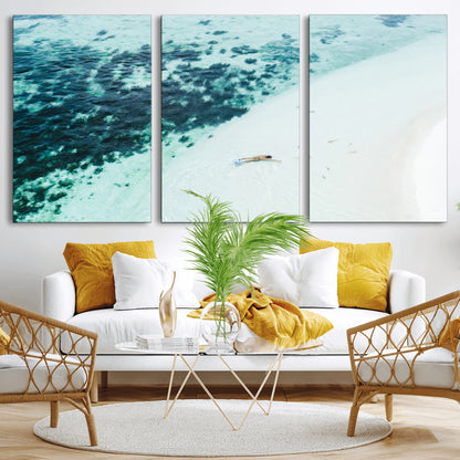 Canvas featuring an aerial view of a swimmer in shallow turquoise waters with coral patterns, ideal for tropical coastal home decor.