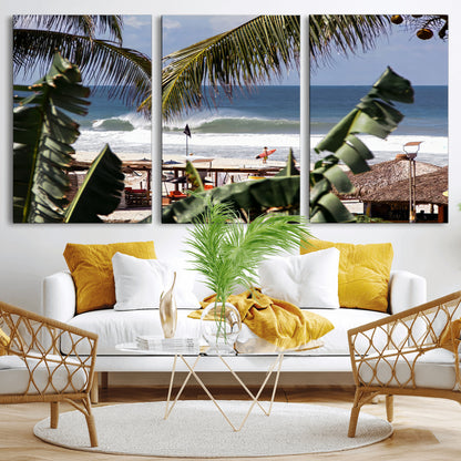 Canvas wall art of a tropical surf scene framed by palm trees, with a surfer on the shore and waves rolling in, ideal for beach-themed decor.