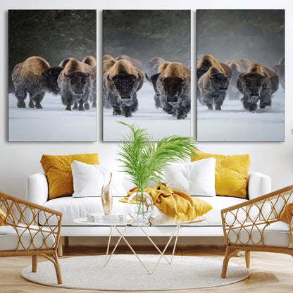 A herd of American bisons walking through deep snow in a forest, evoking a powerful rustic wilderness mood for western-style interiors.