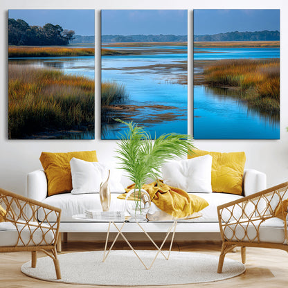 A peaceful marshland scene with calm blue water reflecting the surrounding grasses and trees, capturing the beauty of nature in a serene landscape.