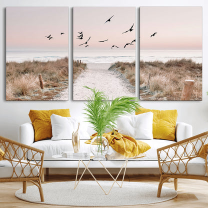 A peaceful coastal pathway leading to the ocean, with birds flying across a soft pastel sky, creating a calm and scenic beach atmosphere.