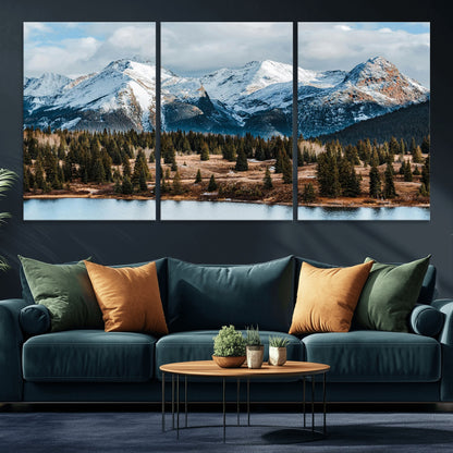 Framed canvas of snowy mountain peaks with pine forest and alpine lake, perfect for winter cabin or wilderness-inspired home decor.
