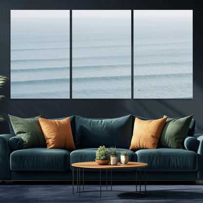 Framed canvas of repeating ocean waves with a distant solo surfer, ideal for minimalist ocean or calm coastal wall decor.