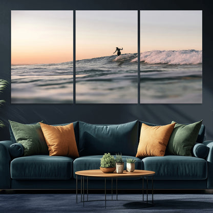 Framed canvas of a female surfer balancing on a wave at sunset, perfect for serene surf or ocean-inspired coastal decor.