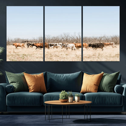 Framed wall art of Texas longhorn cattle walking through a dry, neutral-toned prairie, perfect for rustic farmhouse or western-themed home decor.