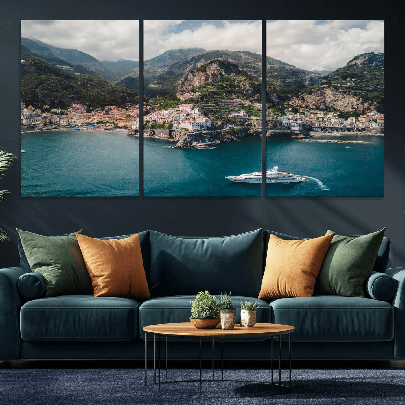 Aerial view of Amalfi Coast, Italy, with colorful hillside houses, lush green mountains, and a luxury yacht sailing in turquoise waters.
