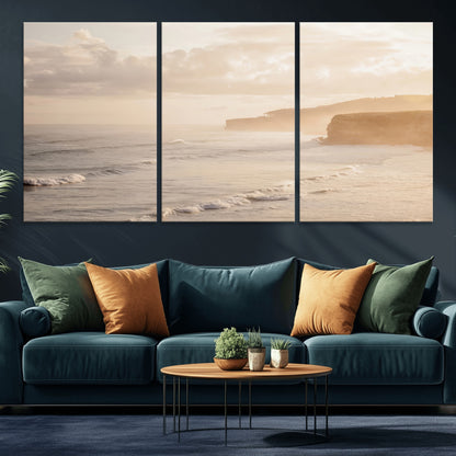 Golden hour seascape with misty cliffs and gentle waves rolling towards the shore, capturing a tranquil and warm coastal atmosphere.