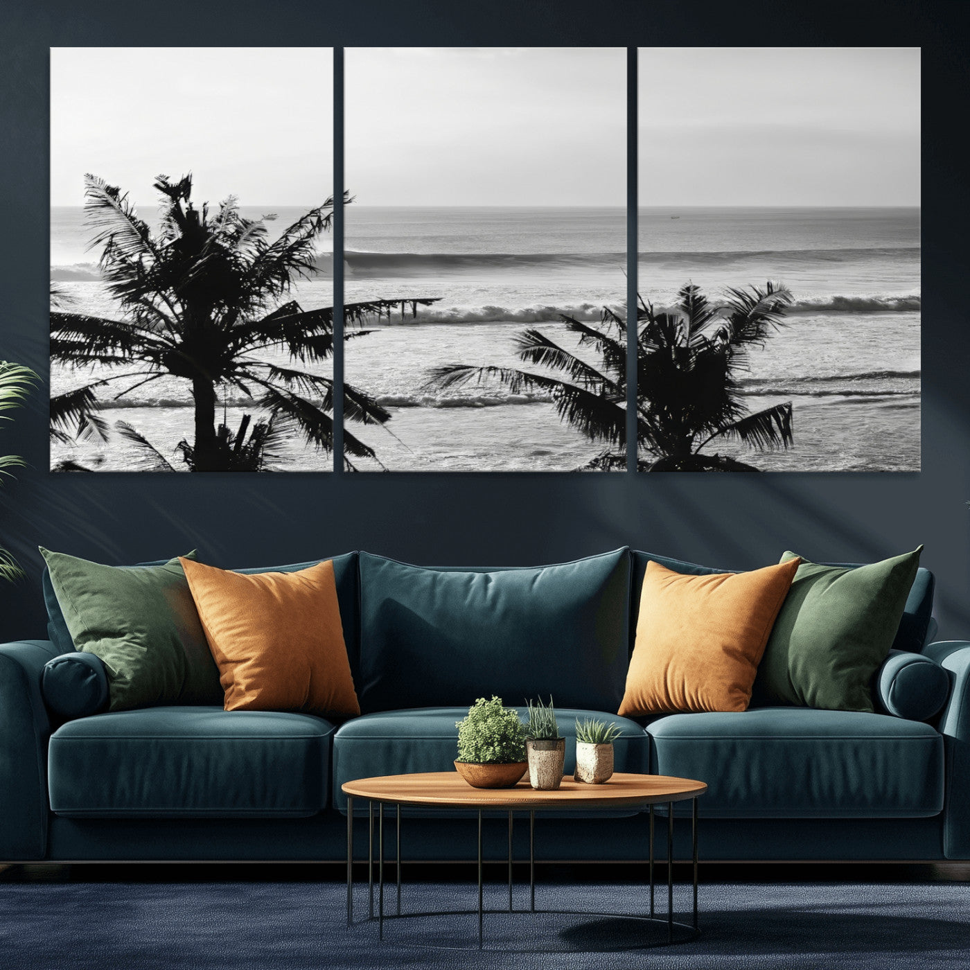 Black and white view of ocean waves crashing on a tropical coastline, framed by silhouetted palm trees under a vast, open sky.