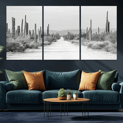 A black and white desert road stretching through a cactus-filled landscape, creating a rugged and timeless southwestern aesthetic with a sense of adventure.