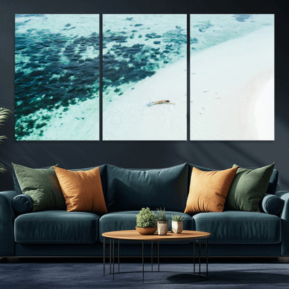 Canvas featuring an aerial view of a swimmer in shallow turquoise waters with coral patterns, ideal for tropical coastal home decor.