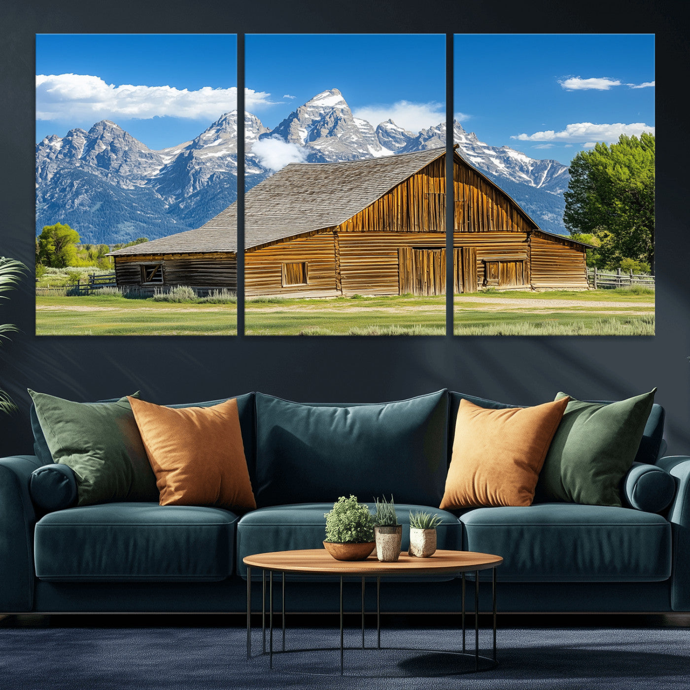 A rustic wooden barn sits in front of towering mountain peaks under a clear blue sky, perfect for farmhouse or cabin style interiors.
