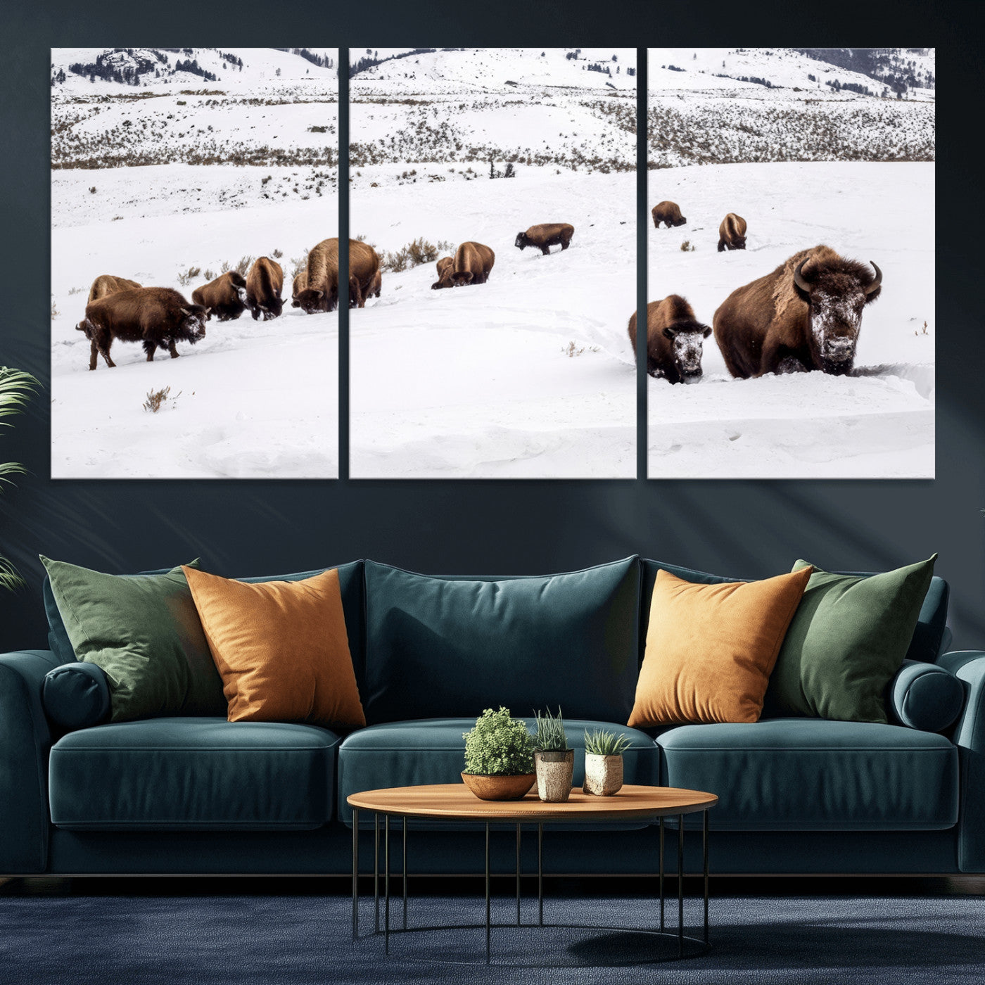 A herd of bison walking through deep snow in a mountain valley, perfect for rustic, cabin or western-themed wall decor.