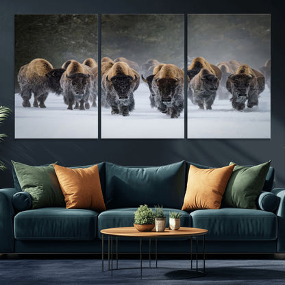 A herd of American bisons walking through deep snow in a forest, evoking a powerful rustic wilderness mood for western-style interiors.