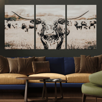 Canvas of a speckled Texas longhorn standing boldly in a field with a herd behind, perfect for rustic western or farmhouse wall decor.