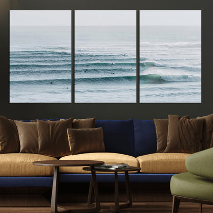 High-angle view of surfers lining up across layered ocean waves, ideal for minimal coastal or surf-inspired room decor.