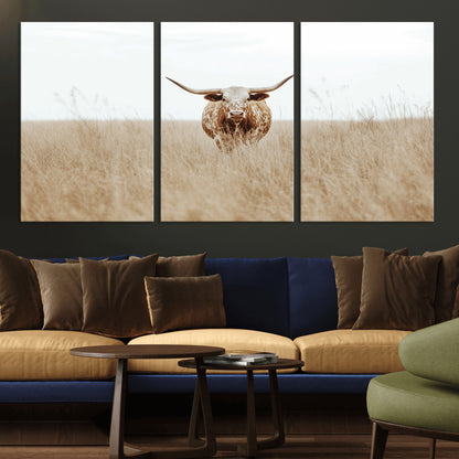 Texas Longhorn bull standing alone in dry grass with neutral tones, ideal for rustic western or cowboy-themed wall decor.