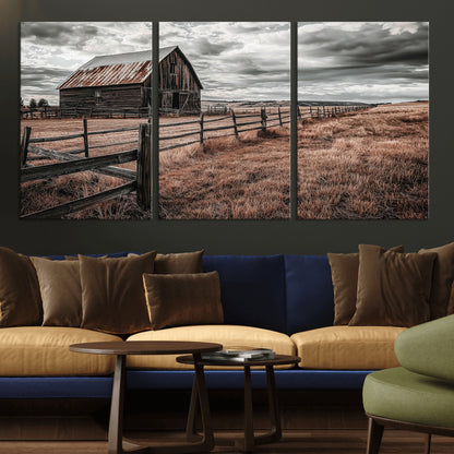 Framed canvas of a rustic barn under a moody sky with weathered fence and dark fields, ideal for farmhouse or rural-style wall decor.