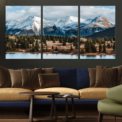 Framed canvas of snowy mountain peaks with pine forest and alpine lake, perfect for winter cabin or wilderness-inspired home decor.