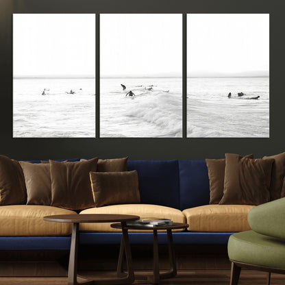 Monochrome photo of surfers riding and waiting on ocean waves, ideal for surf-themed or coastal energy wall decor.