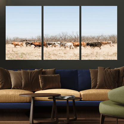 Framed wall art of Texas longhorn cattle walking through a dry, neutral-toned prairie, perfect for rustic farmhouse or western-themed home decor.