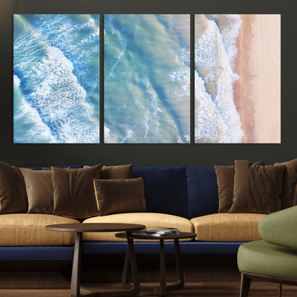 Aerial photo of soft blue waves meeting sandy shore, perfect for modern coastal or beach-themed decor with a light and tranquil aesthetic.