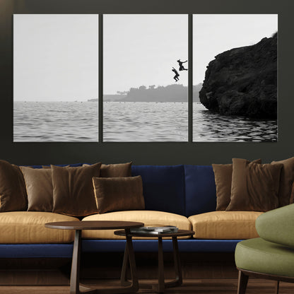 Black and white canvas of two figures cliff jumping into the sea, captured with moody tones, ideal for modern coastal or adventure-themed home decor.   2/2