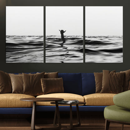 Black and white ocean with a hand making a surfer sign among dark waves, creating a dramatic and minimalist seascape with bold contrast.