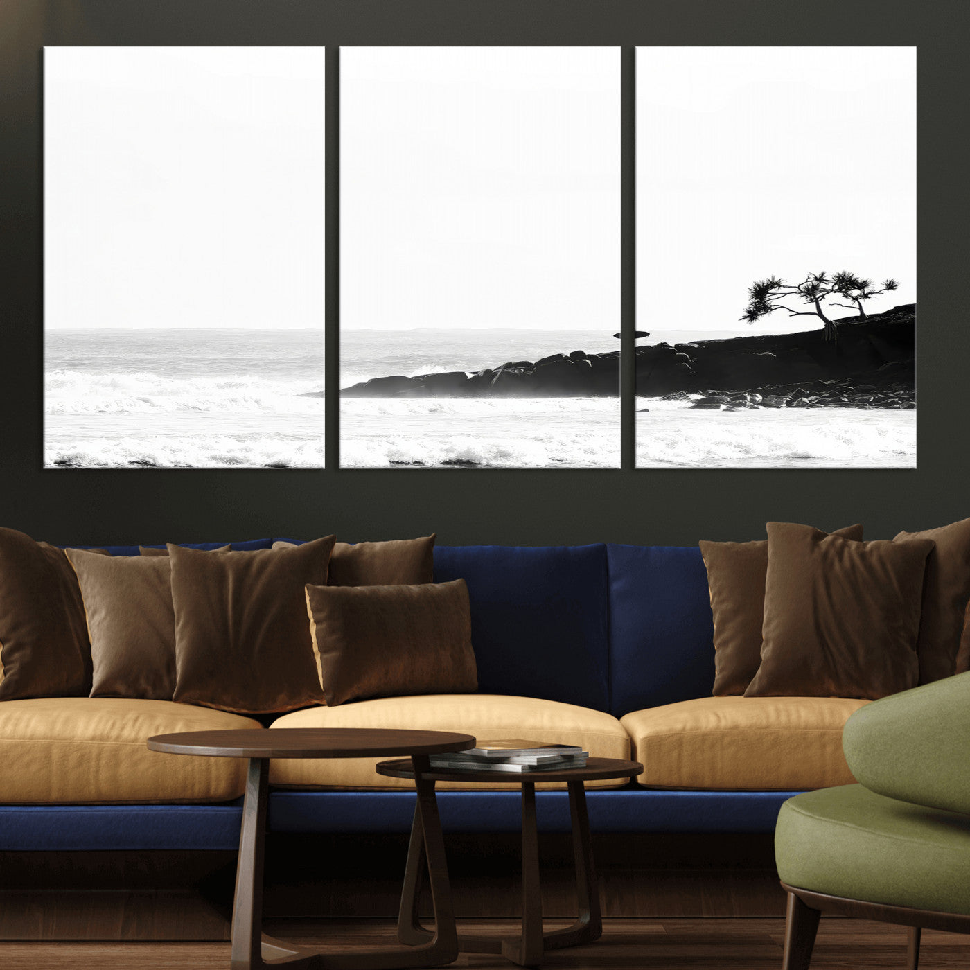 Black and white photo of a surfer standing on rocky cliffs, gazing at the waves, embodying the spirit of adventure and solitude.
