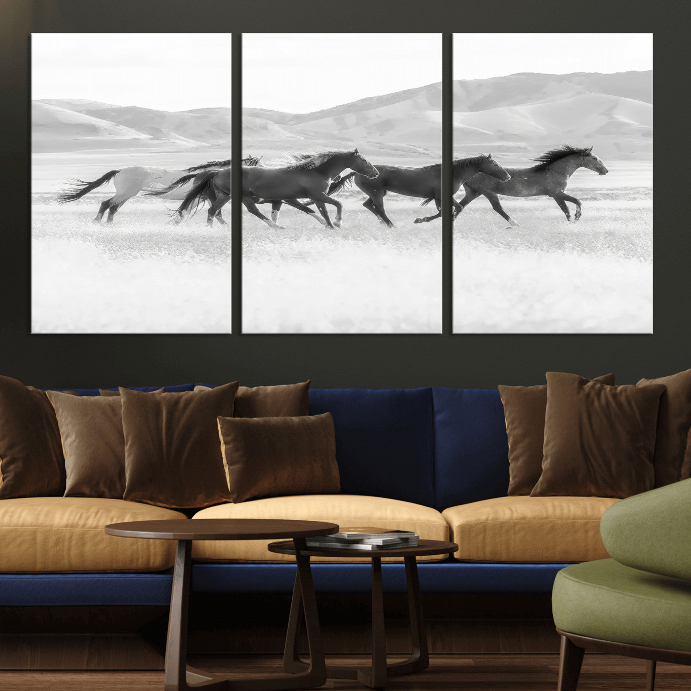 A black and white image of wild horses running freely across an open grassland, capturing the power and beauty of untamed nature in a rustic western setting.