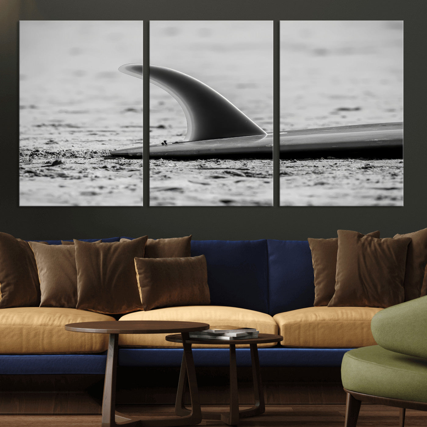 A black and white close-up of a surfboard fin resting on the sandy shore, highlighting minimalist beach aesthetics and classic surf culture.