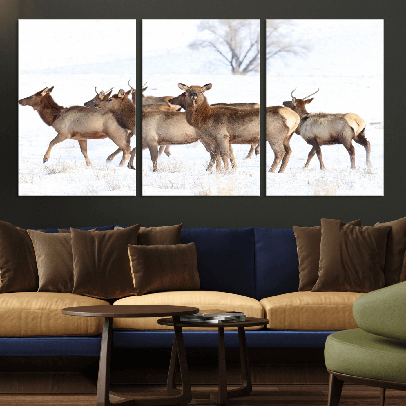 A group of elk standing on snowy terrain with a tree in the background, perfect for rustic or lodge-style winter wall decor.