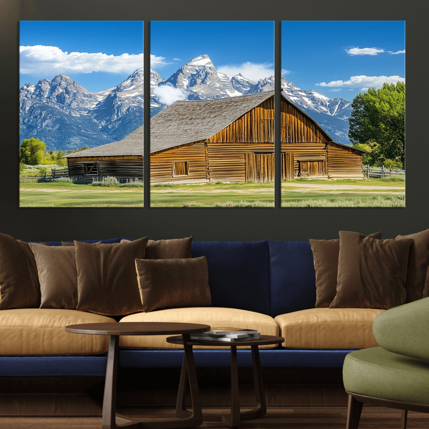 A rustic wooden barn sits in front of towering mountain peaks under a clear blue sky, perfect for farmhouse or cabin style interiors.