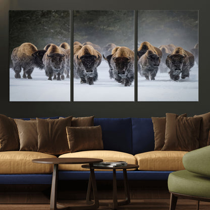 A herd of American bisons walking through deep snow in a forest, evoking a powerful rustic wilderness mood for western-style interiors.