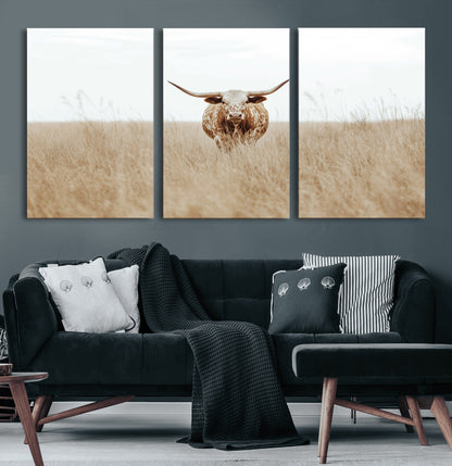Texas Longhorn bull standing alone in dry grass with neutral tones, ideal for rustic western or cowboy-themed wall decor.