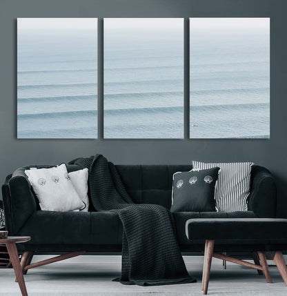 Framed canvas of repeating ocean waves with a distant solo surfer, ideal for minimalist ocean or calm coastal wall decor.