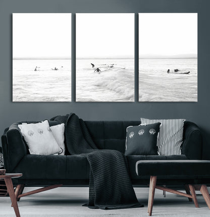 Monochrome photo of surfers riding and waiting on ocean waves, ideal for surf-themed or coastal energy wall decor.