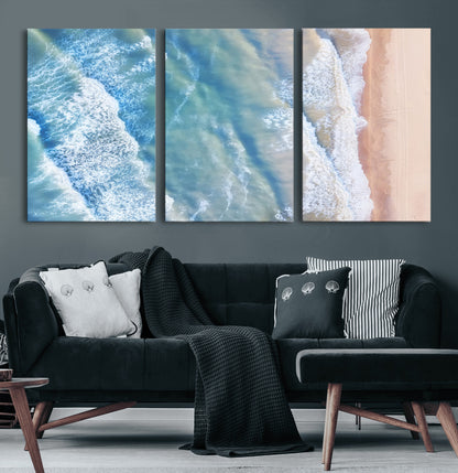 Aerial photo of soft blue waves meeting sandy shore, perfect for modern coastal or beach-themed decor with a light and tranquil aesthetic.