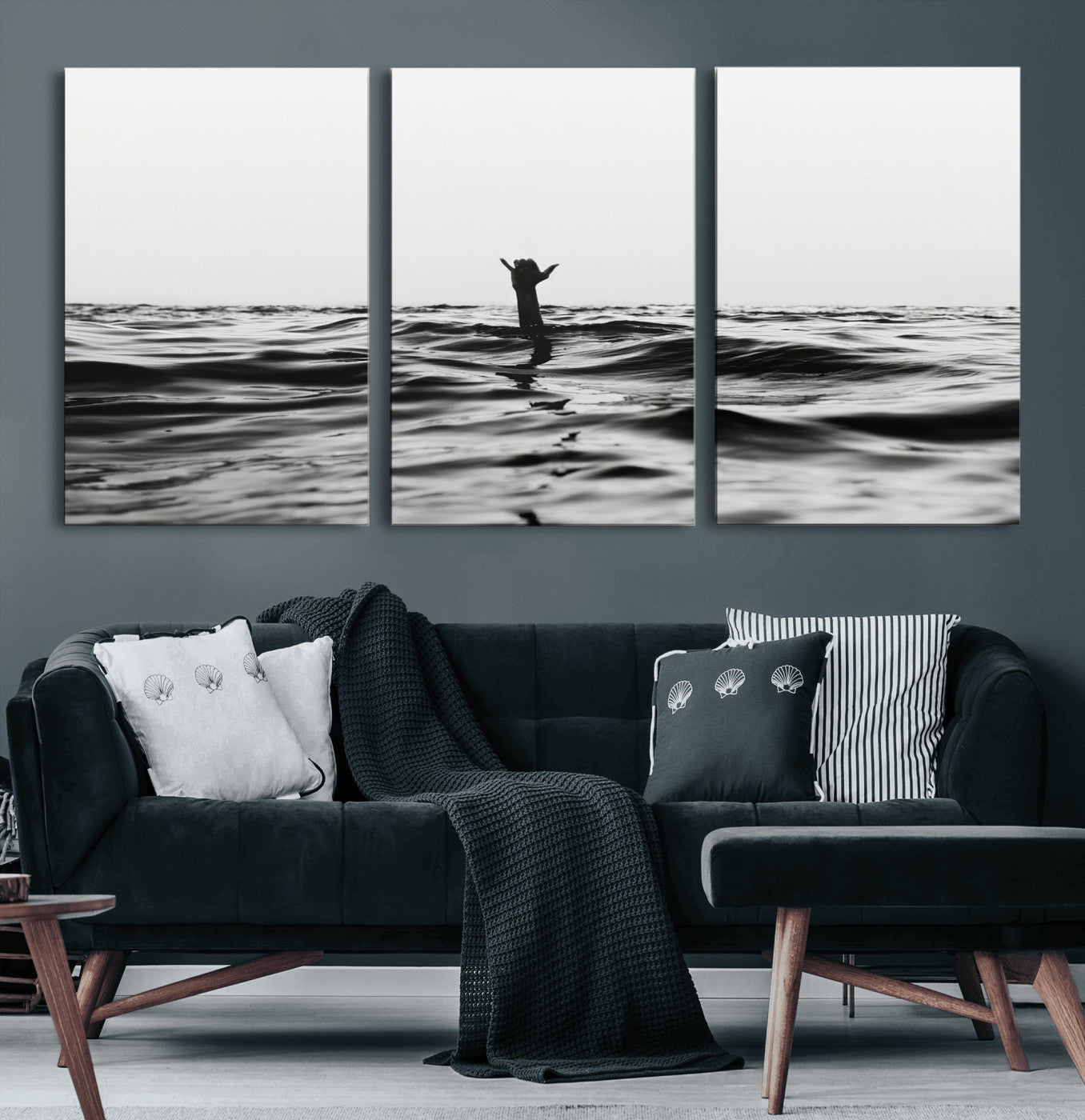 Black and white ocean with a hand making a surfer sign among dark waves, creating a dramatic and minimalist seascape with bold contrast.