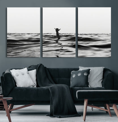Black and white ocean with a hand making a surfer sign among dark waves, creating a dramatic and minimalist seascape with bold contrast.