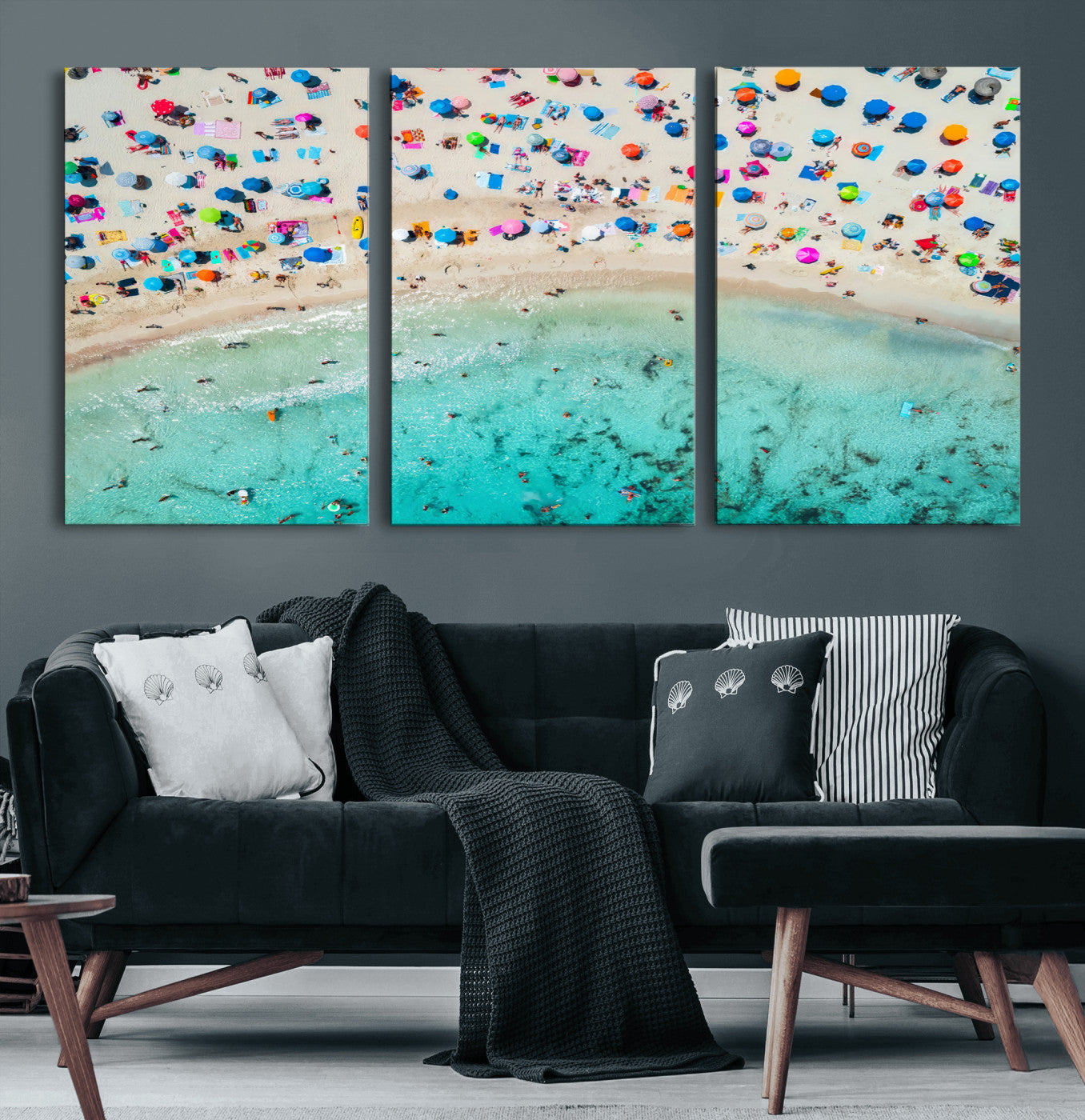 Aerial view of a vibrant beach filled with colorful umbrellas and people enjoying the turquoise ocean, capturing a lively summer vacation scene.