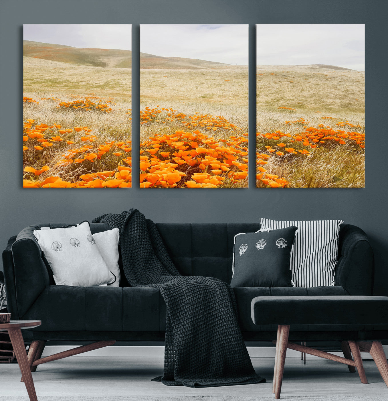 A golden field with vibrant orange poppies blooming across rolling hills under a soft, sunlit sky, creating a warm and rustic landscape.