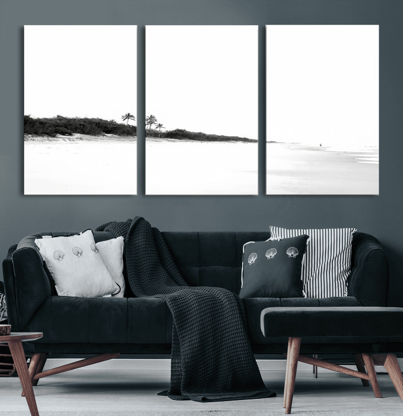 A black and white minimalist coastal scene with a vast open beach, distant palm trees, and a lone figure walking along the shoreline, evoking serenity and solitude.