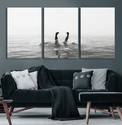 A black and white minimalist water scene capturing a playful splash as a swimmer dives upside down, creating a carefree and artistic aquatic aesthetic.